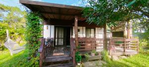 a small wooden house with a porch and a swing at cabaña mara in La Paloma