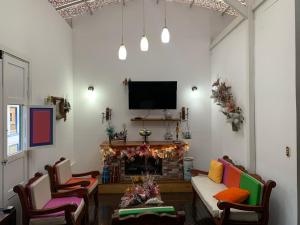 a living room with a fireplace and a tv at Hotel Tibouchina in Filandia