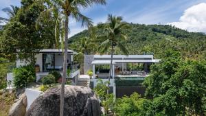 a house with a swimming pool and palm trees at Villa Bond Seaview Villa in Chaweng Noi Beach