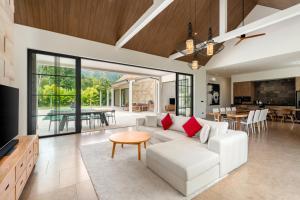 an open living room with a white couch and a table at Villa Mangosteen spacious 3br Pool villa in Ban Thung