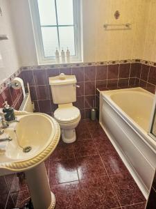 a bathroom with a toilet and a sink and a tub at Enniscrone Guest Rooms in Enniscrone +9 photos