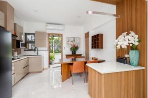 a kitchen with a table and a vase of flowers at Villa Lom Talay - Family Retreat in Ban Thong Phlu