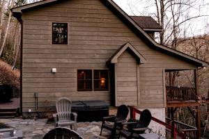 a house with two chairs and a table in front of it at Minutes to Boone, Blowing Rock, HotTub, Firepit in Blowing Rock