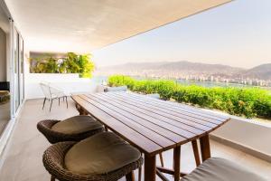 a wooden table and chairs on a balcony with a view at Departamento en Brisas Diamante in Acapulco