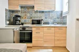 a kitchen with wooden cabinets and a microwave at Modern Flat in Central Athens (Chrysanthemum) in Athens
