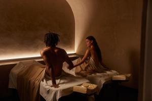 a man and a woman sitting on beds in a room at Pixel Dizengoff Square - Hotel & Spa in Tel Aviv +40 photos