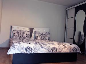 a bedroom with a bed with a black and white comforter at Taf's Small House in Pristina