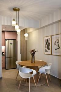 a dining room with a wooden table and white chairs at Acropoli 1 Bedroom Flat with Rooftop Acropolis View in Athens