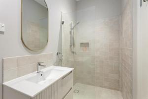 Un baño blanco con lavabo y espejo. en Birdstow Spacious peaceful Stay Sleeps Ten, en Wentworth Falls 14 fotos más