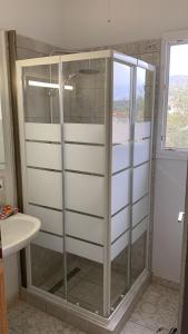 a glass shower in a bathroom with a window at La Bandolaise à Perdika in Perdika