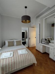 a white bedroom with a bed and a pendant light at Kolonaki 2 bedroom Flat in Athens