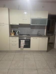 a kitchen with white cabinets and a stove top oven at Filera in Garaguso