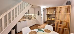a kitchen with white cabinets and a table and chairs at La Camargue Appartment mit Pool in Aigues-Mortes