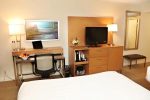 a hotel room with a bed and a desk with a television at enVision Hotel & Conference Center Mansfield-Foxboro in Mansfield