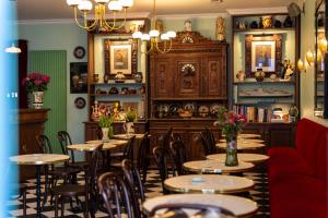 a restaurant with tables and chairs and a red couch at Hôtel Le Croiseur Ginette in Saint Malo