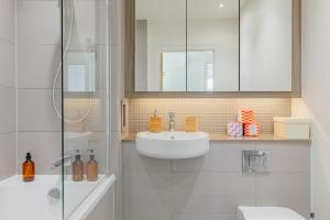 a white bathroom with a sink and a mirror at Gorgeous 1Bd Flat with incredible views of the O2 in London
