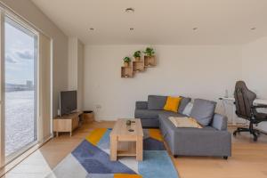 a living room with a couch and a table at Gorgeous 1Bd Flat with incredible views of the O2 in London