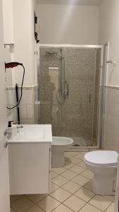 a bathroom with a shower and a toilet and a sink at Home Zeus in Giardini Naxos