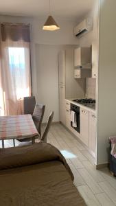 a kitchen with a table and a kitchen with a stove at Home Zeus in Giardini Naxos +3 photos
