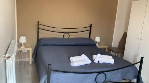 a bedroom with a blue bed with towels on it at Home Zeus in Giardini Naxos