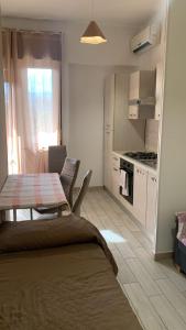 a kitchen with a table and a kitchen with a stove at Home Zeus in Giardini Naxos