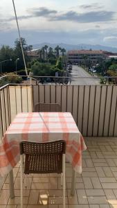 a table and chairs on a balcony with a view of a street at Home Zeus in Giardini Naxos