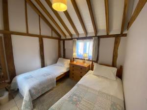 a small bedroom with two beds and a window at Oak Apple in Plaitford +12 photos