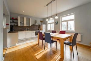 une cuisine et une salle à manger avec une table et des chaises en bois dans l'établissement Forsthaus Wegenerskopf 12 PAX Natur & Ruhe, à Thale