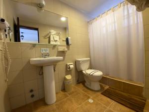 un bagno con un water e un lavandino di Kituandes Hotel a Quito