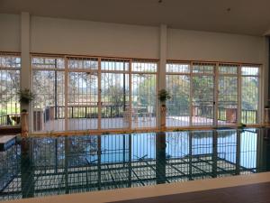 a swimming pool with windows in a building at Thai River House in Ban Kat Khi Lek