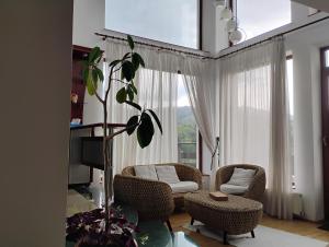 Una sala de estar con dos sillas y una ventana. en Paradise View, en Brasov
