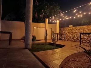 a patio with lights and a stone wall at night at Hotel 230 Valladolid in Valladolid