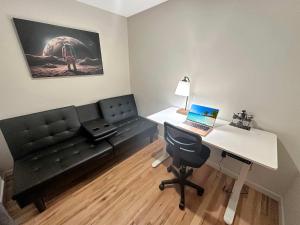 Central Downtown Stay في لا كروس: غرفة معيشة مع أريكة ومكتب مع الكمبيوتر المحمول