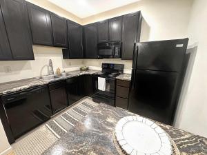 Central Downtown Stay في لا كروس: مطبخ مع دواليب سوداء وثلاجة سوداء
