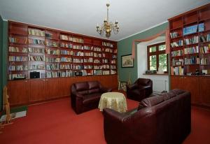 a living room with couches and bookshelves at Pałac Kietlin in Niemcza