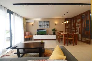 a living room with a couch and a dining room at HE Appart 402 situé à Bonapriso hôtel de l'air avec salle de Gym in Douala