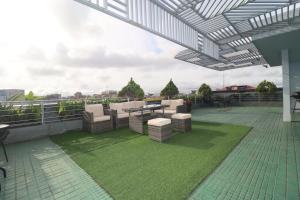 a patio with chairs and a table on a roof at HE Appart 402 situé à Bonapriso hôtel de l'air avec salle de Gym in Douala
