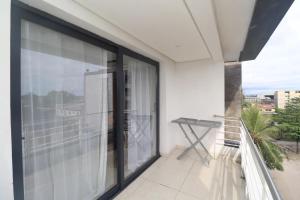 a balcony with sliding glass doors on a building at HE Appart 402 situé à Bonapriso hôtel de l'air avec salle de Gym in Douala +3 photos