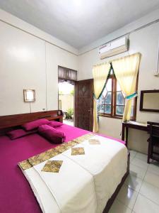 DemanganGaruda Syariah Homestay By Reccoma的一间带大床和书桌的卧室