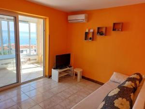 a room with a bed and a television and a balcony at Apartment Jenul in Labin