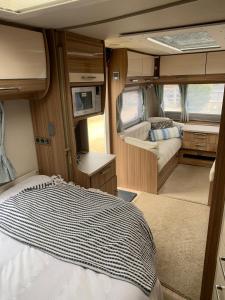 an interior of an rv with a bed and a tv at Country Roost in High Wycombe