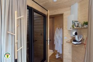 a pivot door in a bathroom with wooden walls at Domaine des Étoiles - Logements Insolites in Gillonnay