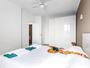 ein weißes Bett mit einem Teller Essen drauf in der Unterkunft Wonderful Attic in Playa Paraiso in Playa Paraiso + 23 Fotos