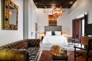 a hotel room with a bed and a couch at Hotel Boutique Casa del Limonero in Seville