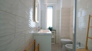 a white bathroom with a sink and a toilet at Panoramic Seaview in Olbia +20 photos