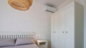 a bedroom with a bed and a white cabinet at Panoramic Seaview in Olbia