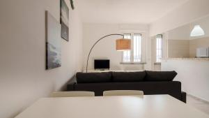 a living room with a couch and a table and chairs at Panoramic Seaview in Olbia