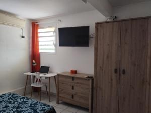 ル・カルベにあるCarbet Horizonのキャビネットとノートパソコンが置かれた机のある寝室