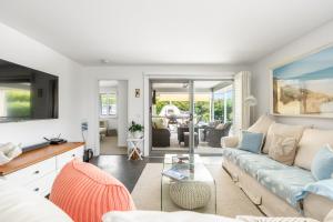 a living room with a couch and a table at Orford Coastal Retreat by Peppy Beach Retreats in Orford +23 photos