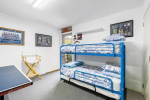 a bedroom with two bunk beds and a desk at Orford Coastal Retreat by Peppy Beach Retreats in Orford